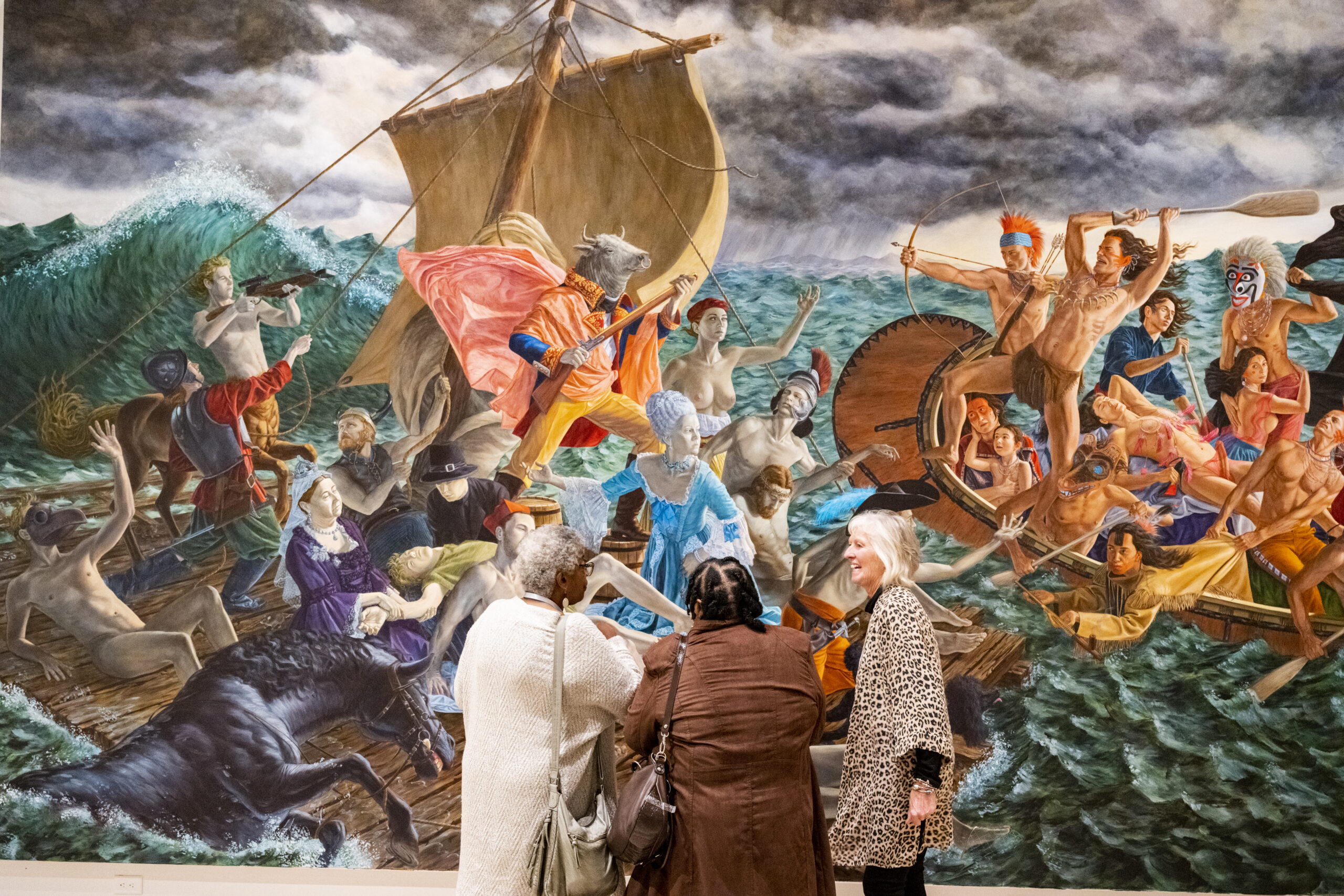 Two older women stand in front of a giant art work